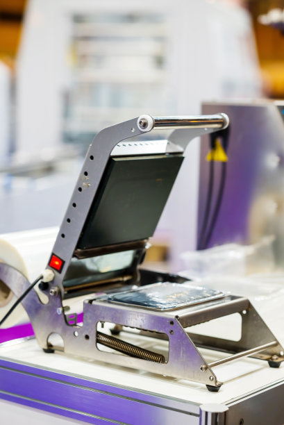 用铝箔密封塑料盒的装置。工业技术和包装材料的概念。高质量照片图片下载