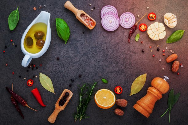 牛排概念与深色石头背景。用复制空间制作牛排的材料。各种草药和调味料迷迭香，鼠尾草，月桂叶，罗勒，大蒜和胡椒。图片下载