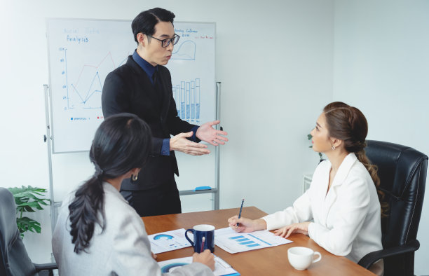 亚洲商人在办公室会议上向公司同事介绍他的工作。商务人士在会议上讨论公司的项目。图片下载