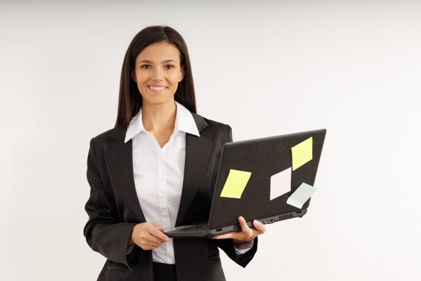 一个年轻的女商人的肖像与笔记本电脑在她的手中。图片下载