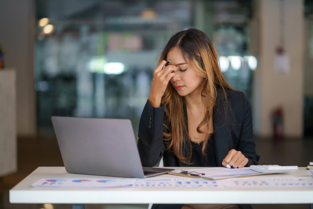 过度工作和压力的年轻亚洲女性坐在办公室的工作场所。图片下载