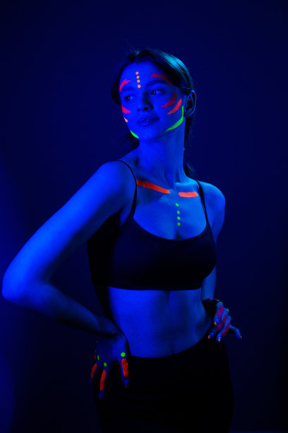 在霓虹灯下用紫外线化妆的女孩。图片下载
