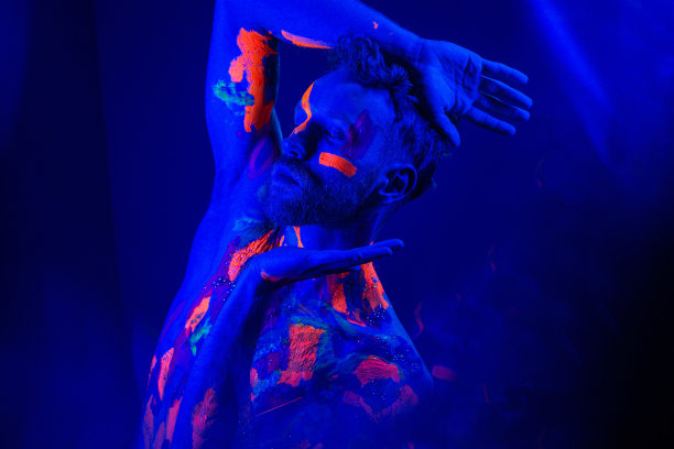 在锐舞派对上跳舞的帅哥脸上挂着荧光画图片下载