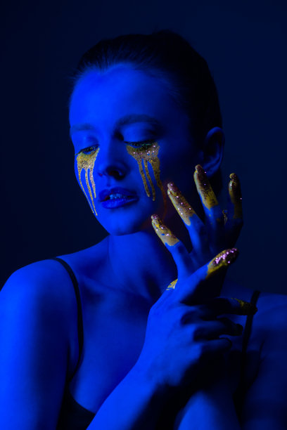 时尚的肖像。一个身上涂着荧光颜料的女孩在霓虹灯下摆姿势。图片下载