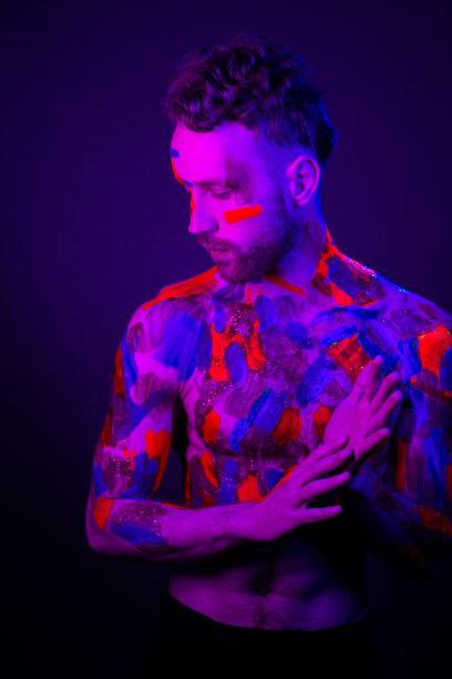一个男人的时尚肖像，在他的身体上涂上紫外线颜料和霓虹灯在赛博朋克风格。图片下载