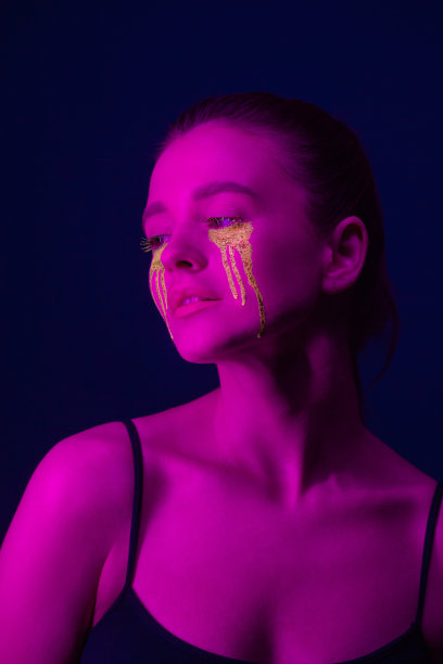 时尚的肖像。一个身上涂着荧光颜料的女孩在霓虹灯下摆姿势。图片下载