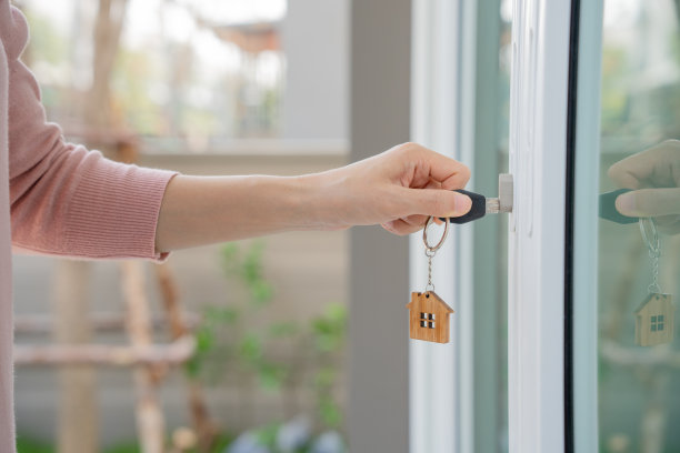 搬家，搬迁。女人在新房子里拿着钥匙链。搬进新家。购买或租赁房产。单位租赁，租赁物业，新房东，住宅，贷款，抵押。图片下载