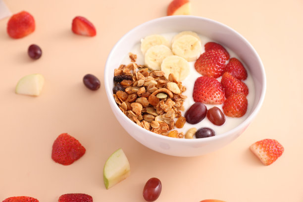 一碗格兰诺拉麦片，酸奶和浆果孤立在蛋奶酒的颜色背景图片下载
