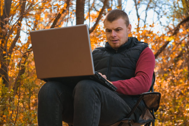 在秋季森林中远程工作的自由职业男性图片下载