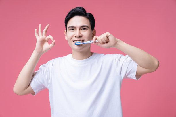 年轻的亚洲人拿着牙刷的背景图片下载