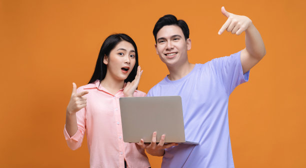 年轻的亚洲夫妇使用笔记本电脑的背景图片下载