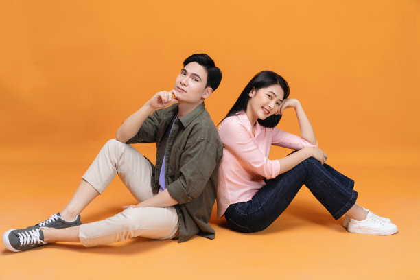 年轻的亚洲夫妇坐在背景上图片下载