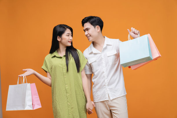 年轻的亚洲夫妇拿着购物袋的背景图片下载