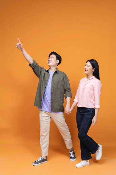 年轻的亚洲夫妇站在背景上图片下载