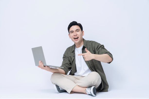 年轻的亚洲商人坐在后台使用笔记本电脑图片下载