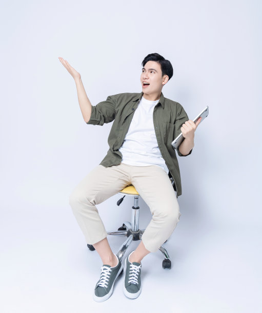 年轻的亚洲商人坐在椅子上，使用笔记本电脑的背景图片下载