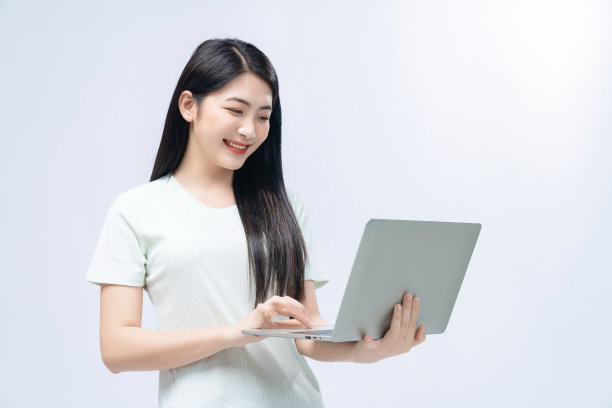 年轻的亚洲女孩拿着笔记本电脑的背景图片下载