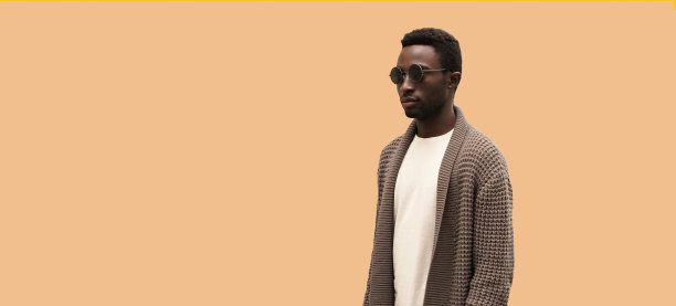 时尚的年轻非洲男子模特肖像穿着针织开衫孤立的棕色背景，空白的复制空间为广告文字图片下载