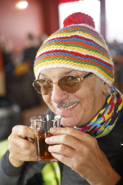 冬季运动肖像男子滑雪者滑雪后在滑雪场。喝热茶。图片下载