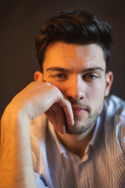 黑发男子在衬衫在工作室的黑色背景图片下载