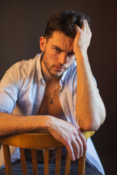 黑发男子在衬衫在工作室的黑色背景图片下载