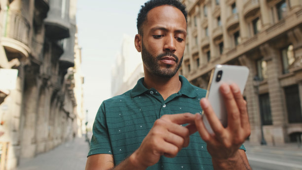 一个年轻人站在路边用手机的特写镜头图片下载