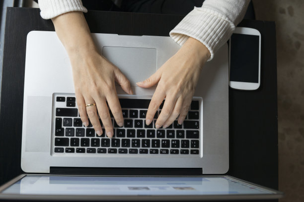 一个女人的手在笔记本电脑上打字的细节图片下载