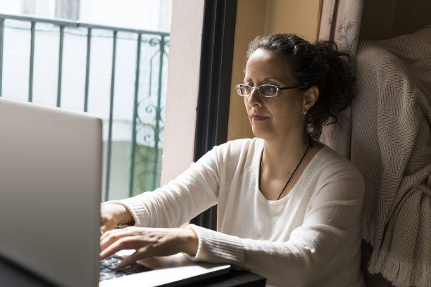 一个女人坐在笔记本电脑前。图片下载