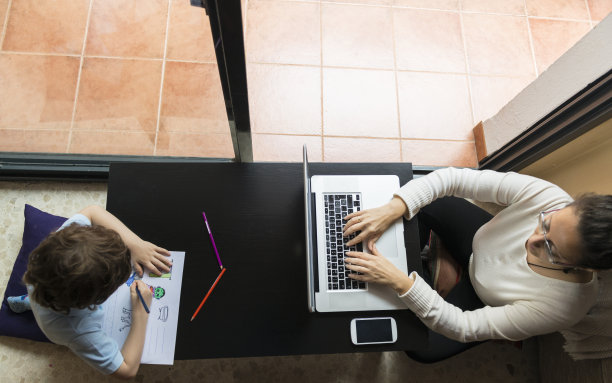 一个女人和一个孩子坐在地板上干活。图片下载
