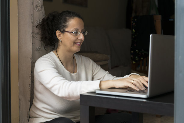 一个女人坐在笔记本电脑前。图片下载