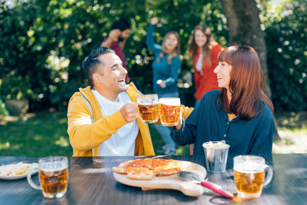 朋友们在后院聚会时喝着冰镇啤酒敬酒图片下载