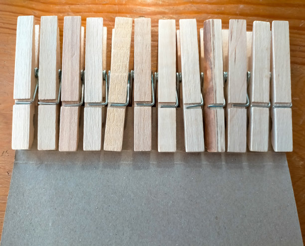 用来挂衣服的木制衣夹，排成一行的钉子，上面有一个灰色的纸板，有复制空间(家居概念)图片下载