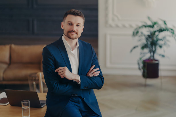 成功自信的商人靠在办公桌上的肖像图片下载