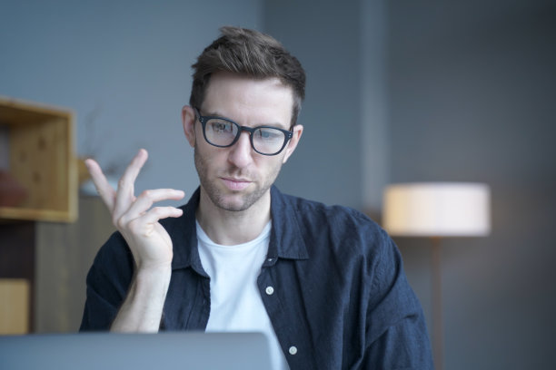 年轻专注的德国人老师在笔记本电脑上与学生进行在线课程图片下载