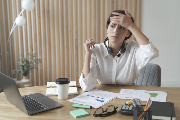 劳累过度生病的年轻意大利女办公室职员触摸她的额头检查体温图片下载