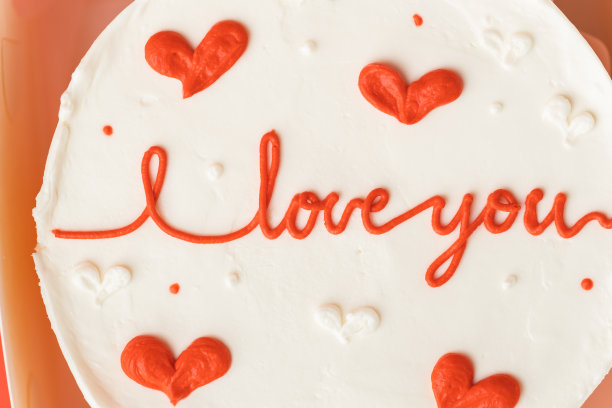韩式便当蛋糕，白色礼盒，红色节日背景。小蛋糕上有我爱你的题词。情人节快乐。平躺图片下载