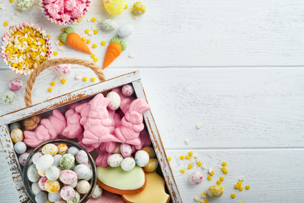 甜蜜的复活节概念。甜蜜的复活节孩子节日品种棉花糖兔子，巧克力复活节蛋，糖果，兔子，零食在白色的木制背景。平铺复活节的装饰思路。模拟。图片下载