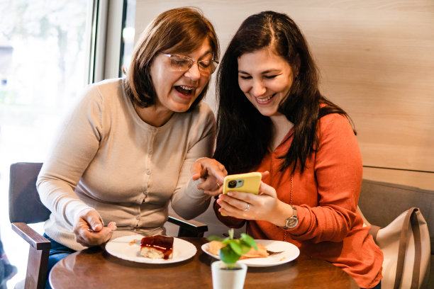 母亲和女儿在咖啡馆里吃蛋糕图片下载