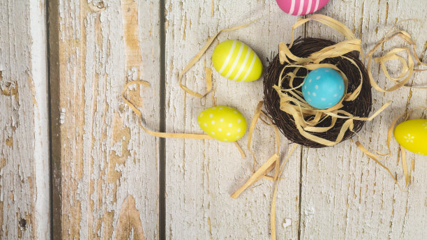 白色木质背景上的彩色复活节彩蛋。复活节假期概念，平铺，俯视图。本空间图片下载