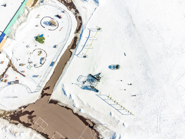 空中无人机俯瞰学校操场设备被雪覆盖。图片下载