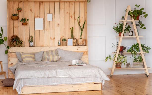 质朴风格的卧室。斯堪的纳维亚式的室内设计，大床和木墙。植物的公寓图片下载