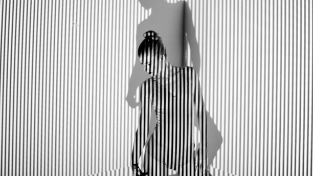 一名女子在带带子的墙上练习芭蕾舞姿势。图片下载