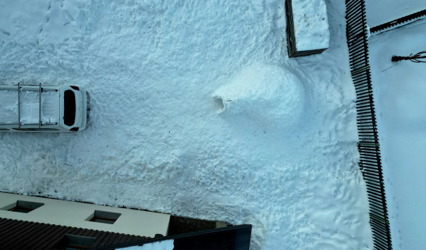 一个灰色的金属屋顶在山区环境。新的泰坦锌板屋顶耐用，无腐蚀性。屋顶上的一层雪很容易就掉下来了，木板栅栏。滑动的雪，烟囱，窗户图片下载