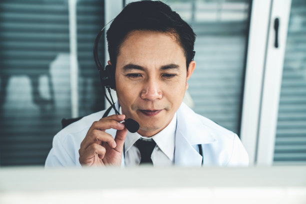 医生戴着耳机在诊所或医院积极视频通话。远程保健和远程医疗服务的概念。图片下载