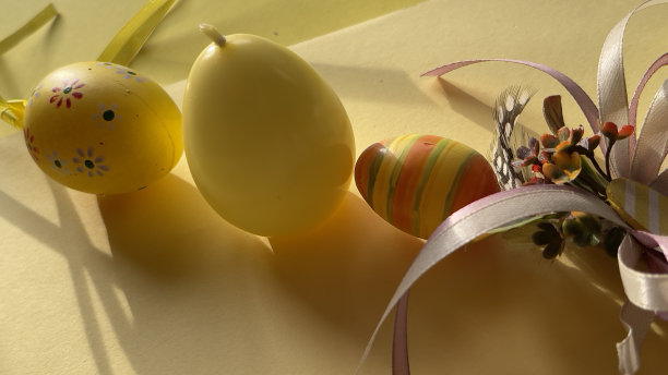 复活节装饰彩蛋颜色粉红色，黄色，蓝色，兔子黄色背景图片下载