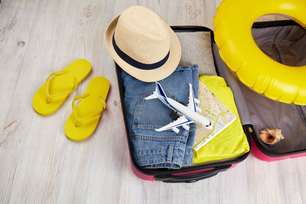 打开装有衣服和休闲用品的行李箱。暑假出游，为旅行做准备图片下载