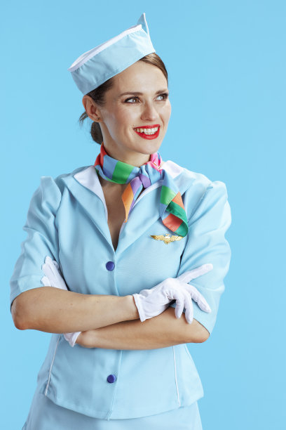 微笑的现代空中小姐在蓝色望向远方图片下载