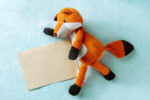 用一只玩具狐狸做模型。棕色牛皮纸模型与空白贺卡图片下载