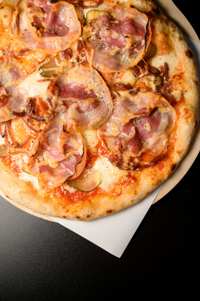 圆形披萨和培根在木砧板上的剪裁照片图片下载