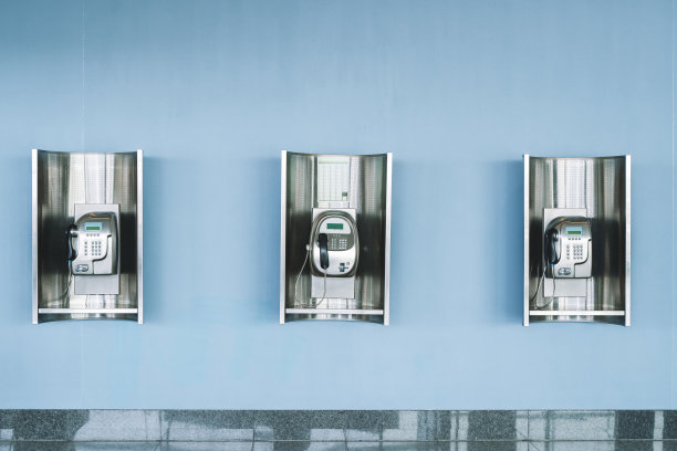墙上有公用电话。公共场所用于付费通话的现代付费电话。图片下载